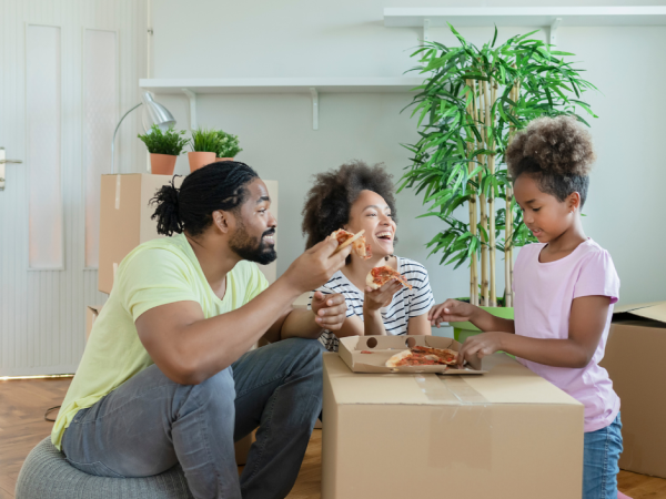 Family laughing while enjoying their first meal in new home