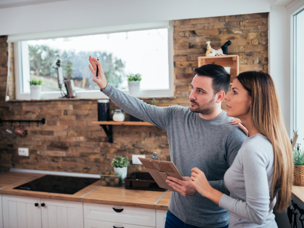 Man and woman in kitchen discussing maintenance tasks