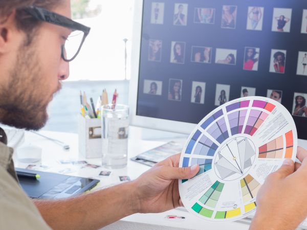 Man with glasses looking at colour wheel and deciding on colour scheme