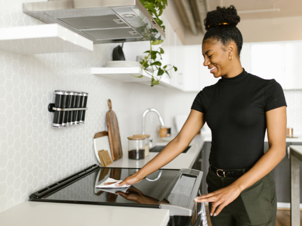 Women happily cleaning her brand new electric stove top in her kitchen