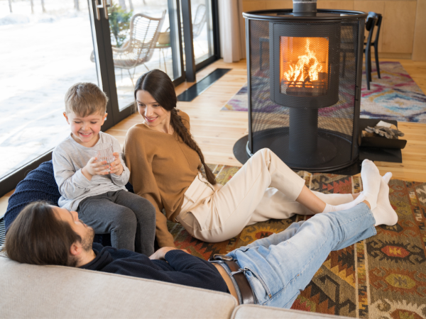 Young family sitting in front of fireplace