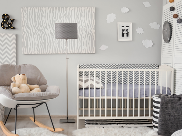 baby bedroom with grey walls, crib, and teddy on chair