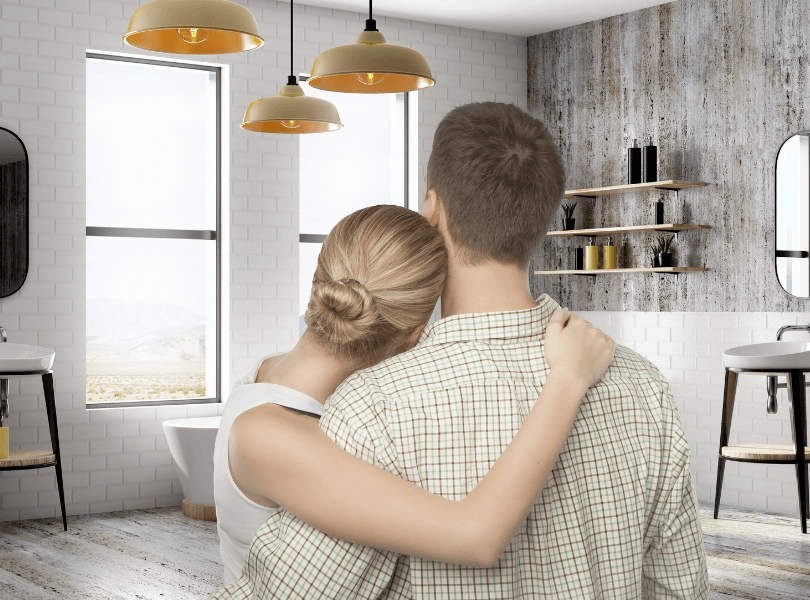 woman hugging man while looking at decorated bathroom