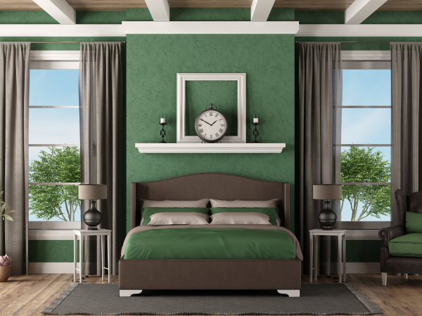 bedroom in forest green with tall windows, bed, and beige curtains