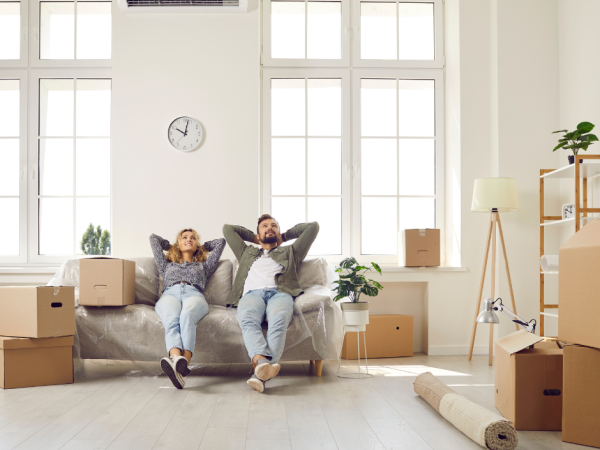 couple relaxing on couch surrounded by boxes