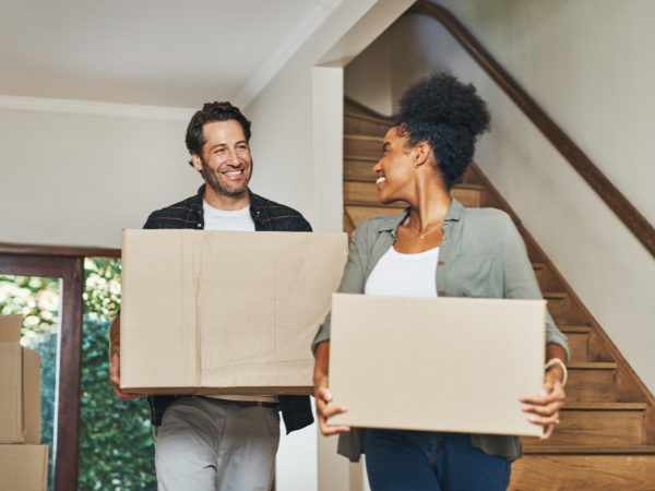 couple-holding-boxes-in-new-home