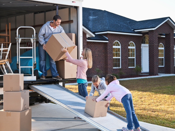 family unloading moving boxes from truck