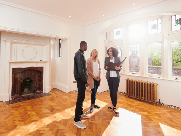 female property practitioner standing in tenanted property with young couple