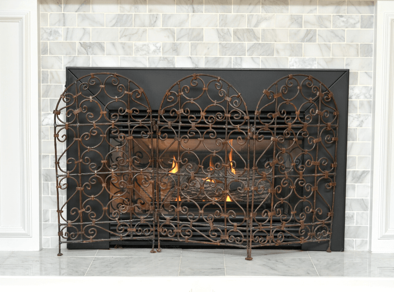 white marbled brick fireplace with fire screen
