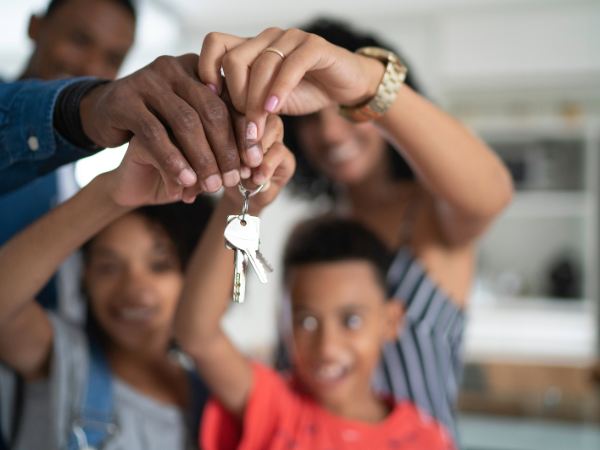 happy family holding up keys to their new house