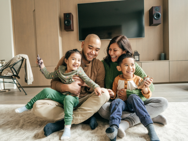 happy family, parents and two young children, sitting in holiday home