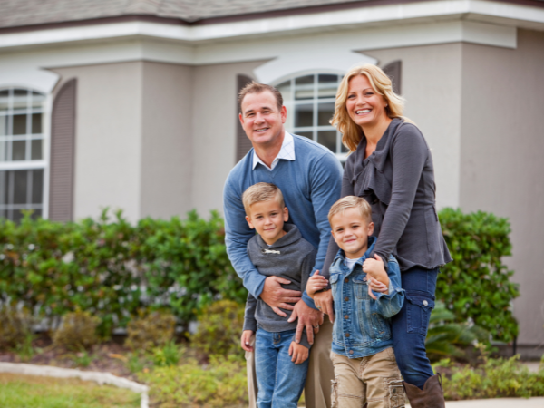 happy young family standing in front of their new rental property