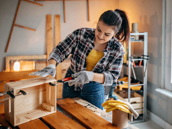 happy young woman making diy upgrades to wooden furniture