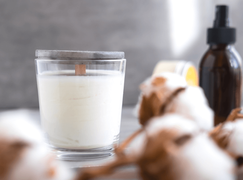 scented candles and fragrance bottle on table