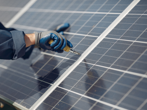 man-with-white-helmet-near-solar-panel