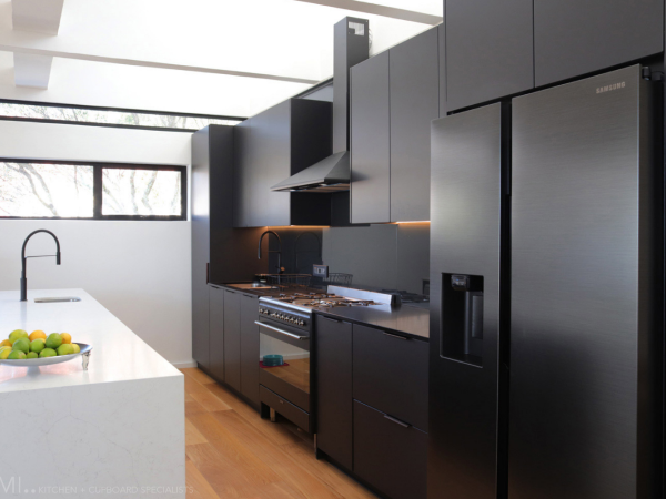 matte-black-vinyl-wrap-kitchen-cabinets-with-blackened-glass-splashback-and-engineered-stone-countertops