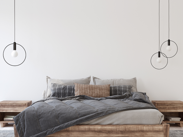 minimal bedroom in greige with hanging lights and pillows on bed
