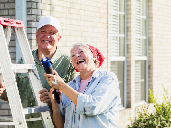 old couple performing maintenance tasks on their property