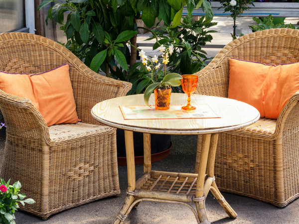 patio furniture with orange cushions and surrounding plants