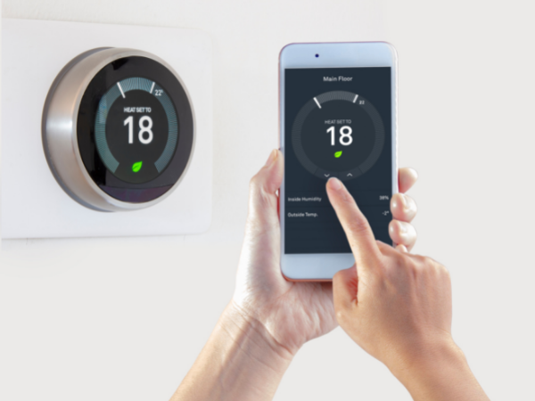 person adjusting smart thermostat