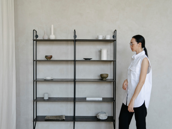 interior designer standing next to arranged open shelves