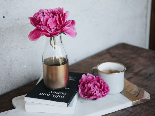 pink flowers and books on wooden coffee table
