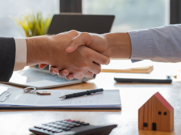 property practitioner shaking hands with new residential real estate investor