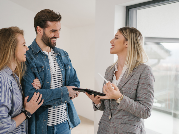 real estate agent speaking to happy couple