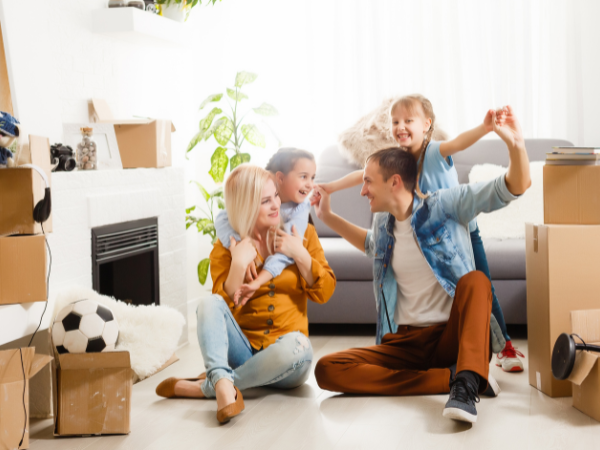 young family sitting in the lounge together surrounded by boxes