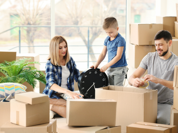 young family unpacking boxes in their new upsized home 